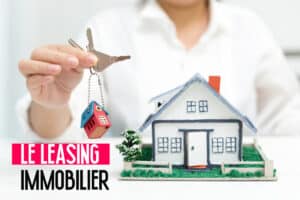 Main tenant des clés au-dessus d'une maquette de maison avec le texte "LE LEASING IMMOBILIER" en avant-plan.