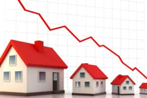 Une image illustrant une maison avec une flèche vers le bas, symbolisant la baisse des taux de crédit immobilier.