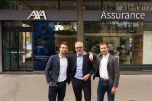 Trois agents d'assurance souriants devant une agence AXA en France.